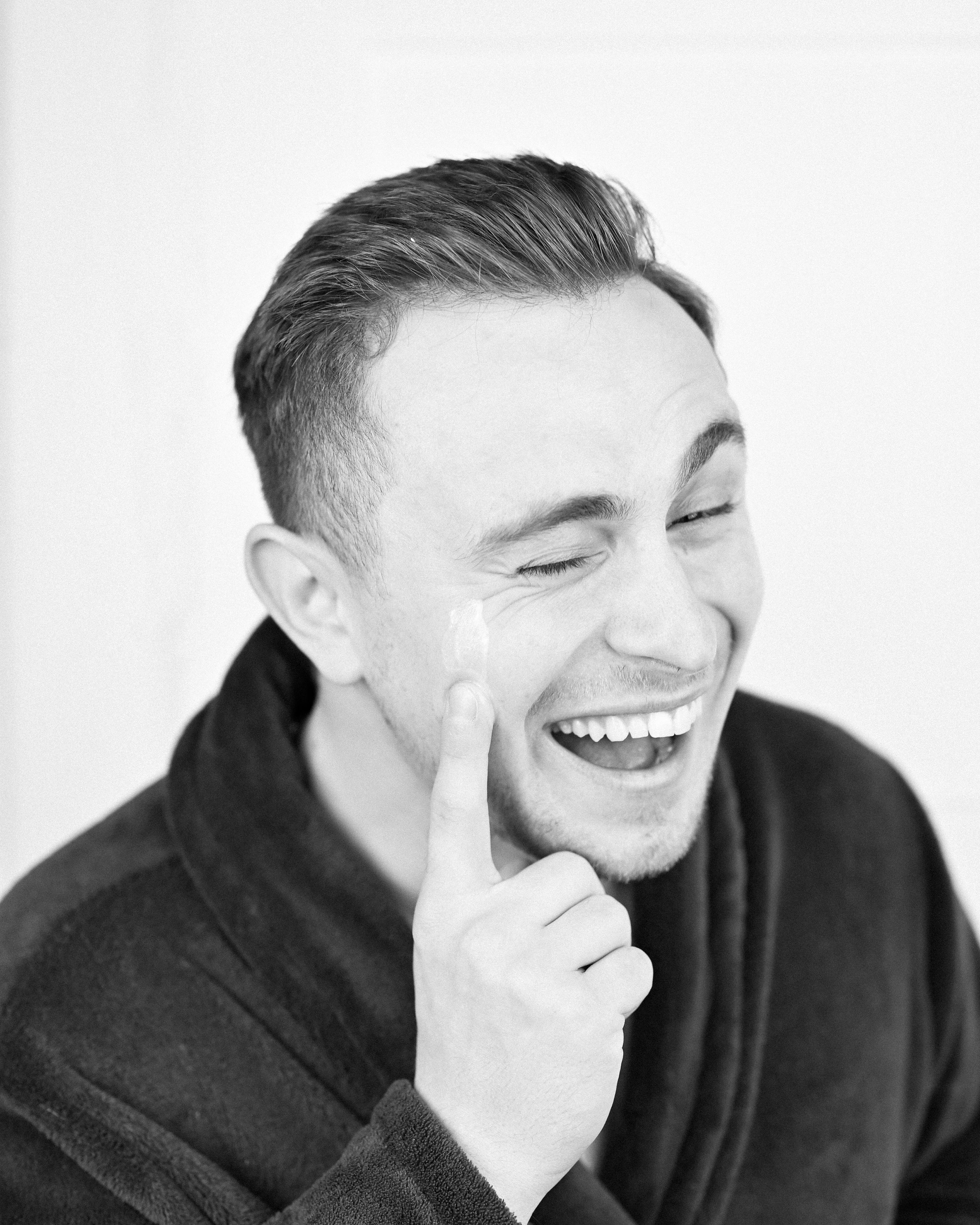 A man applying BEAUHEIT skincare and enjoying his routine.